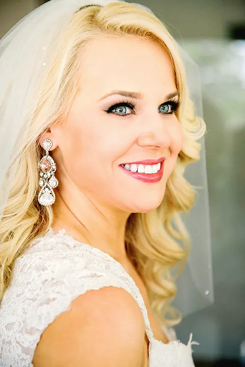 Blonde bride smiling with drop earrings