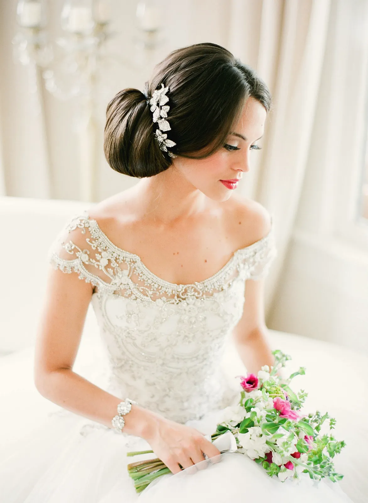Bride in lace holding a pastel bouquet