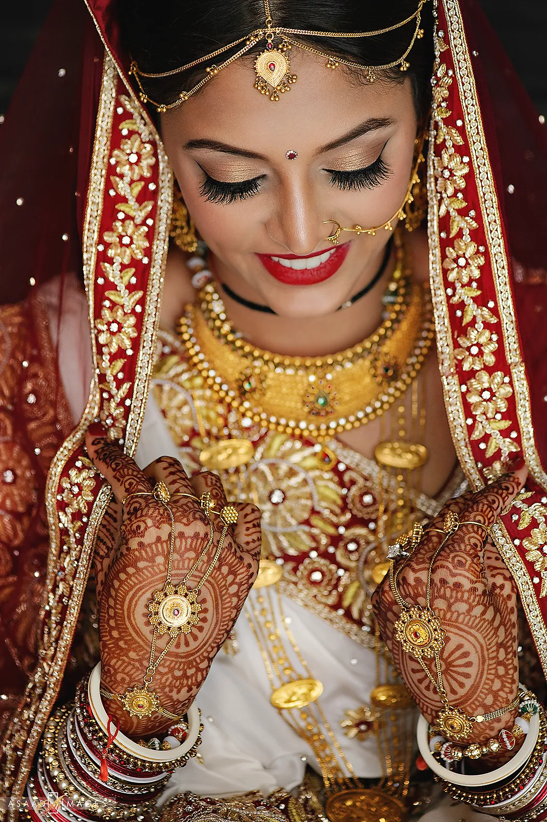 Bride showing her mehndi in red and gold