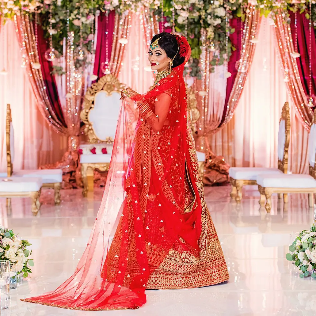 Bride in red at a floral mandap