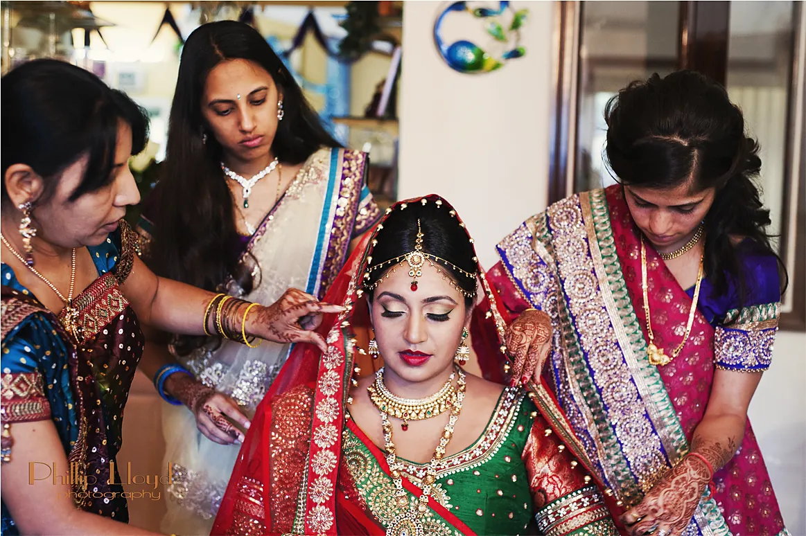 Bride being dressed by family members