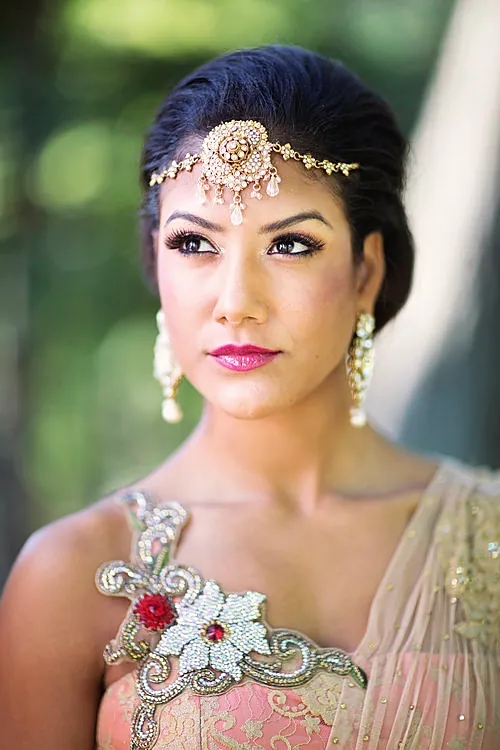 Bride in blush pink with a jeweled matha patti