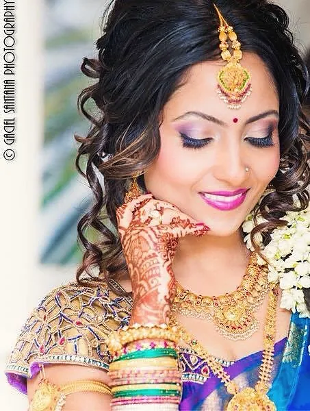South Asian bride with purple eyeshadow and mehndi
