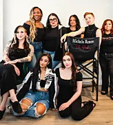 The Michele Renée The Studio team gathered around a director's chair