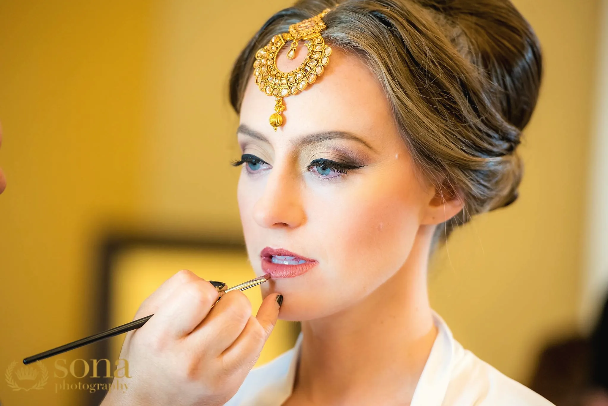 Artist finishing a bride's lips on the wedding morning